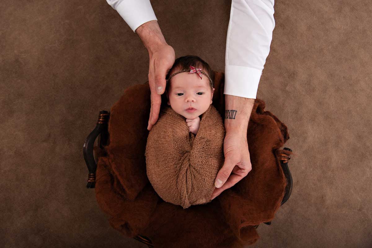 Neugeborenenshooting-Foto-mit-den-Haenden-seines-Vaters